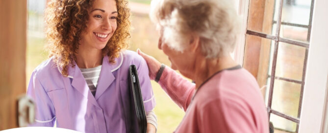 A happy caregiver enters the home of a client, representing in-home recovery care.