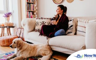 A woman relaxes with her dog while sipping on tea, representing how self-care can combat caregiver stress.