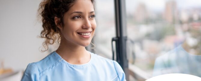 A caregiver smiles and looks hopeful, showing the kind of attitude that can help new professional caregivers.