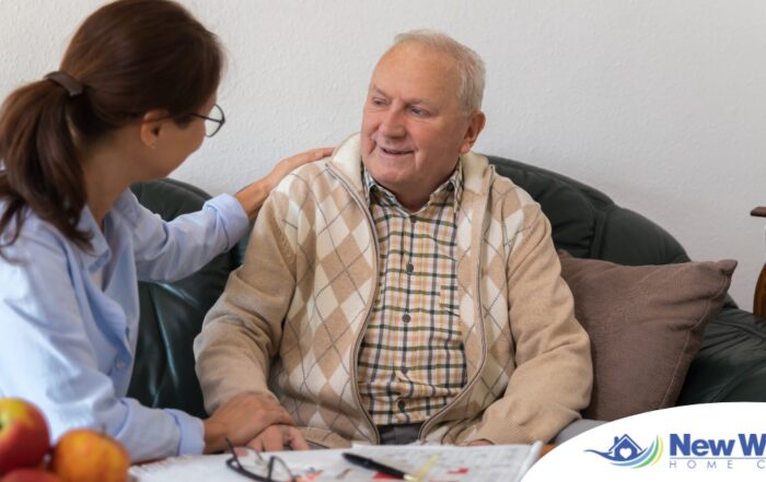 A caregiver compassionately listens to an older man, representing the kind of patience and empathy that help with communicating with clients who have dementia.